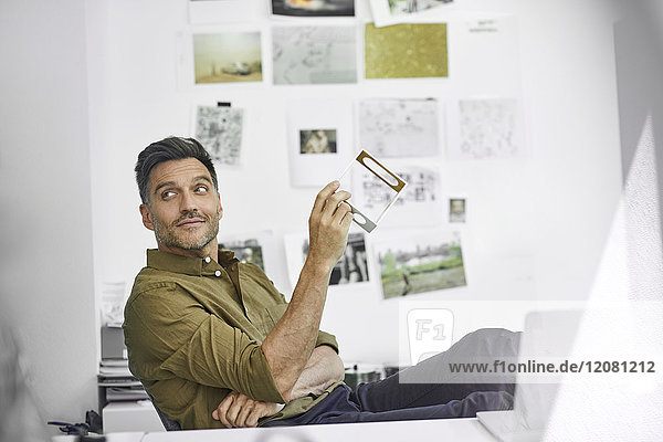 Porträt eines lächelnden Mannes am Schreibtisch in seinem Büro mit Bauteil