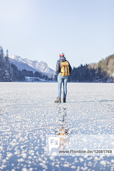 Deutschland  Berchtesgadener Land  Rückansicht der Frau mit Rucksack am gefrorenen Königssee