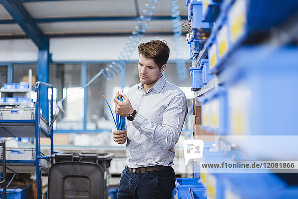 Businessman standing in shop floor  testing products