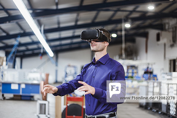 Firmenmitarbeiter mit VR-Brille in der Werkstatt