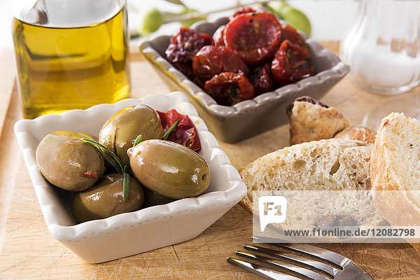 Antipasti  eingelegte Oliven  eingelegte Tomaten  Olivenbrot  Olivenöl und Salz