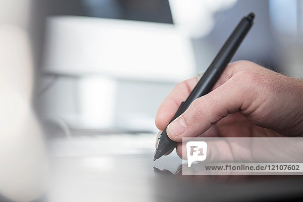 Beschnittene Ansicht eines Mannes  der mit einem digitalen Stift schreibt