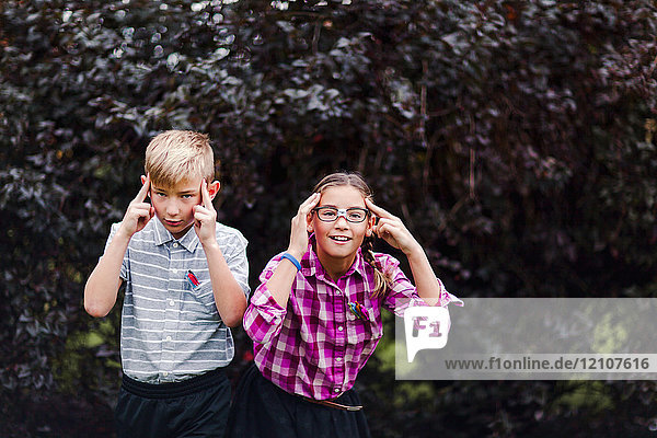 Siblings dressed up as nerds  hands on head looking at camera