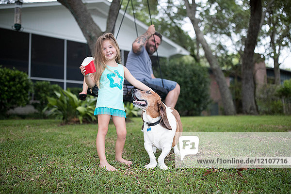 Vater und Tochter im Garten mit Haushund