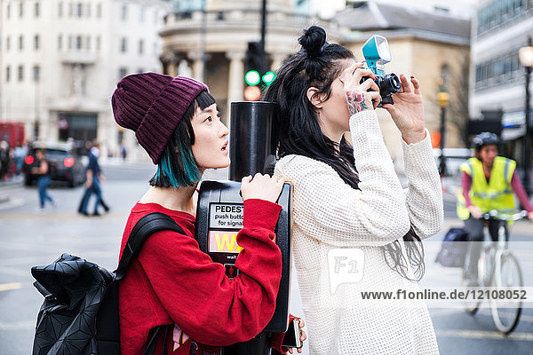 Zwei junge stilvolle Frauen fotografieren auf der Straße  London  UK