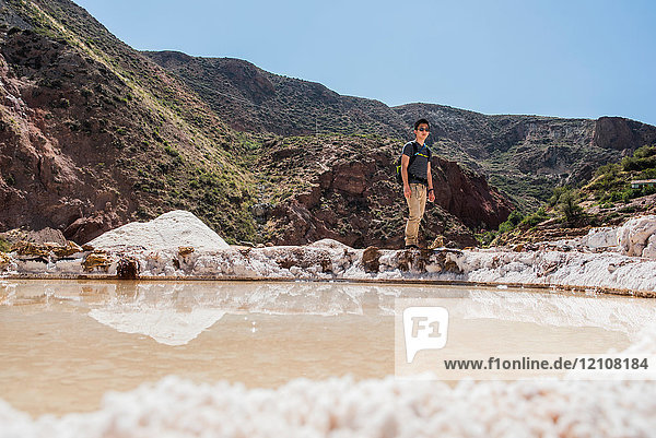 Mann erkundet Maras-Salzbergwerke  Cusco  Peru  Südamerika