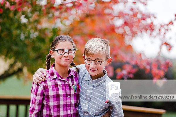 Siblings with arms around each other dressed up as nerds