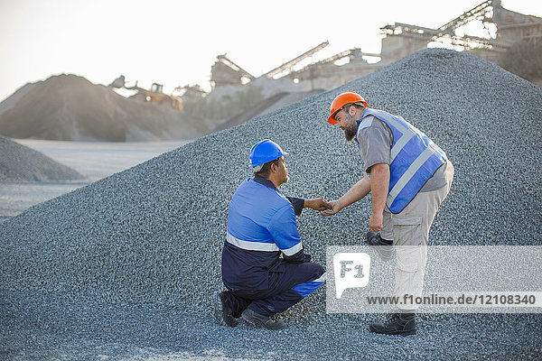 Zwei Steinbrucharbeiter im Steinbruch bei der Überprüfung von Zuschlagstoffen