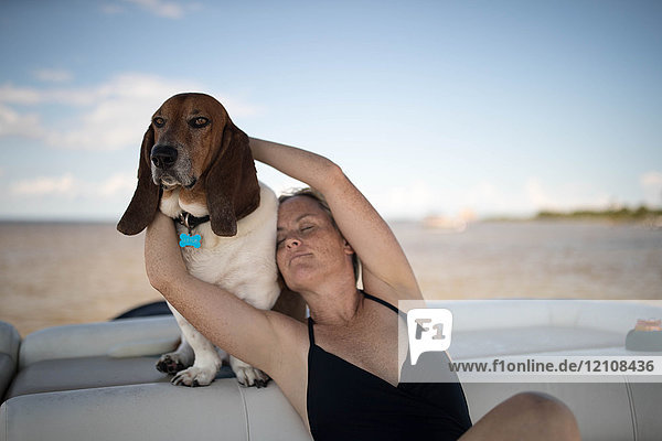 Frau und Haushund entspannen sich auf dem Boot