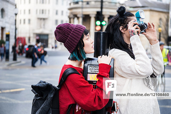 Zwei junge stilvolle Frauen fotografieren auf der Straße  London  UK