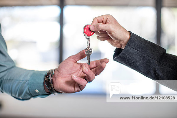 Immobilienmakler übergibt Schlüssel an Hauskäufer  Nahaufnahme