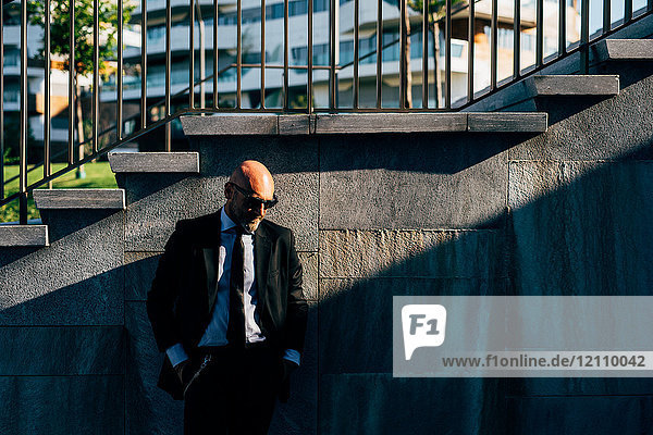 Porträt eines reifen Geschäftsmannes im Freien  neben Stufen stehend  nachdenklicher Ausdruck