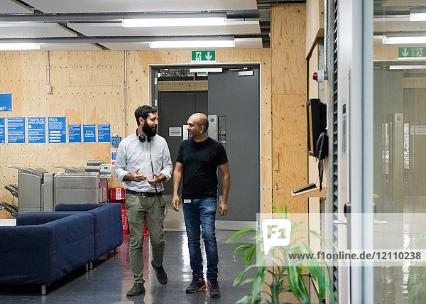 Colleagues walking through office chatting