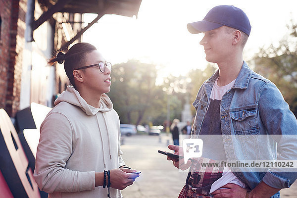Zwei junge Männer unterhalten sich auf der Straße in der Stadt