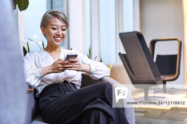 Businesswoman using smartphone smiling