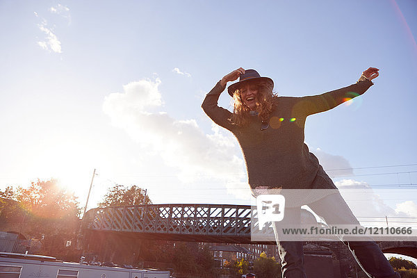 Frau balanciert am Kanal  Brücke im Hintergrund