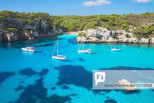 View of Cala Macarelleta bay with blue sea and anchored yachts Menorca Balearic Islands Spain