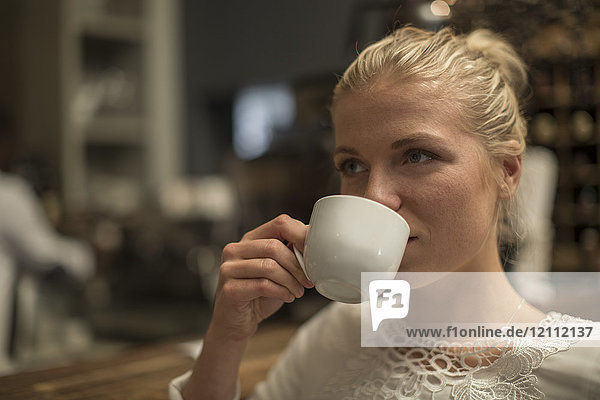 Junge Frau trinkt eine Tasse Kaffee in einem Café