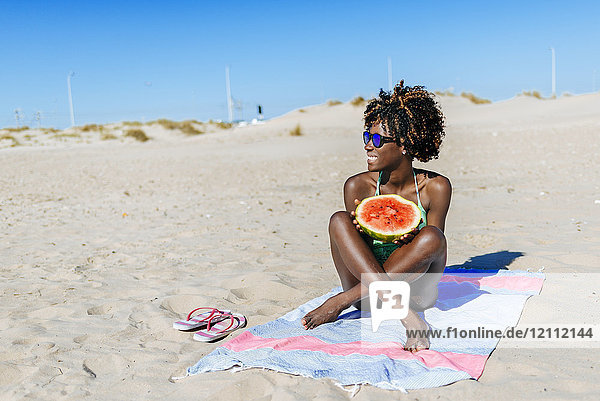 Glückliche junge Frau mit Wassermelone am Strand