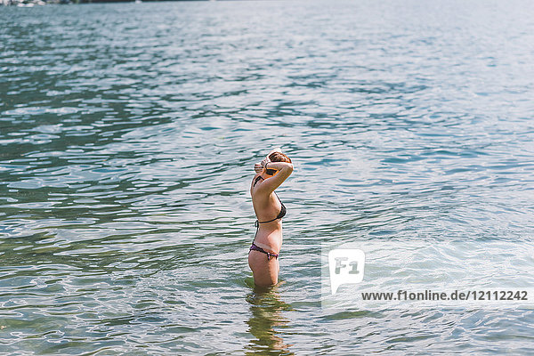 Junge Frau im Bikini knietief im Comer See  Lombardei  Italien