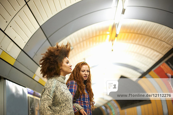 Two young women on subway platform  waiting for train