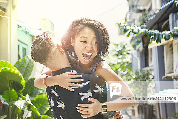 Junger Mann hebt und umarmt Freundin in Wohngasse  Shanghai Französische Konzession  Shanghai  China