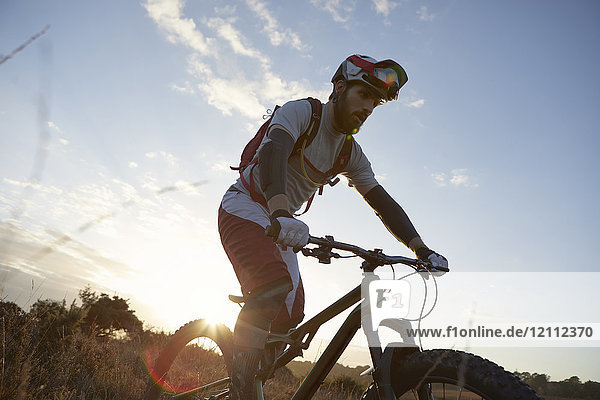 Männlicher Mountainbiker beim Radfahren im Moor
