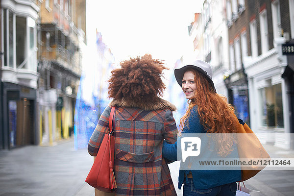 Zwei junge Frauen  die Arm in Arm auf der Straße gehen