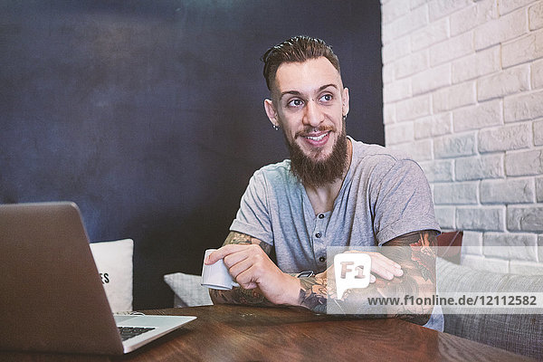 Junger männlicher Hipster im Café mit Laptop  Shanghai Französische Konzession  Shanghai  China