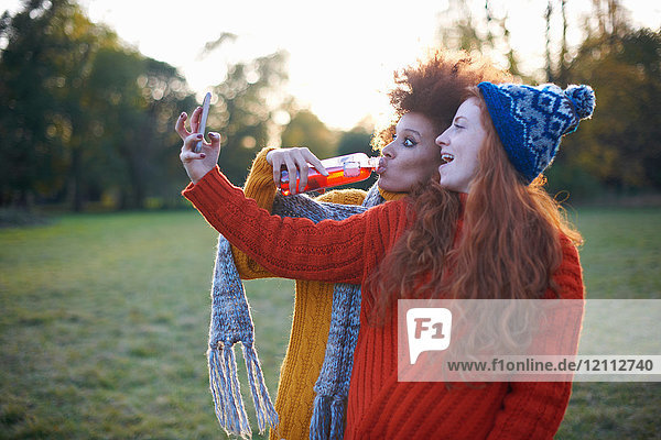 Two young women  in rural setting  taking selfie  using smartphone