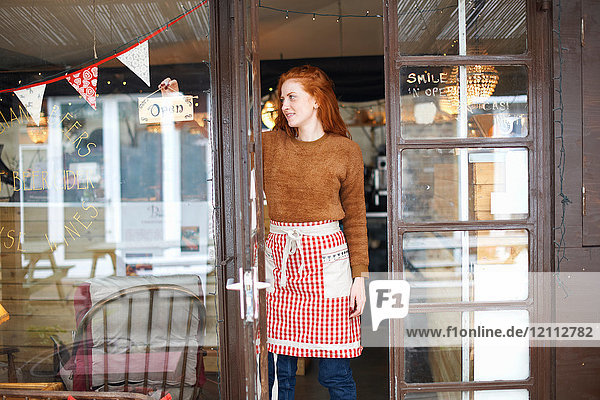 Portrait of small business owner in cafe doorway