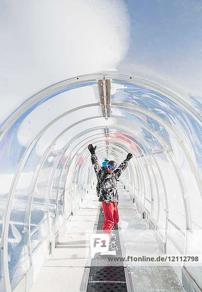 Portrait of snowboarder in ski run tunnel  on moving walkway