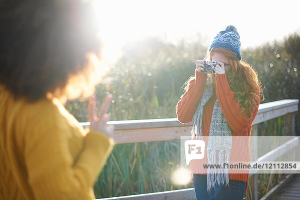 Woman photographing friends with digital camera