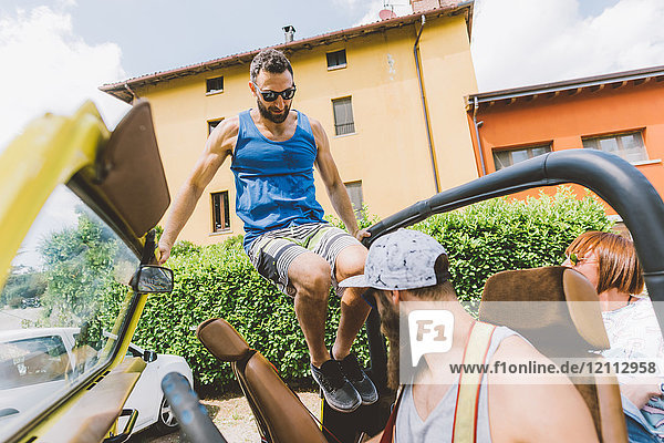 Junger Mann auf Autoreise springt in Geländewagen  Como  Lombardei  Italien