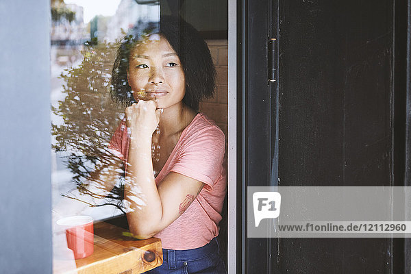 Frau  die durch das Fenster eines Cafés blickt  Shanghai Französische Konzession  Shanghai  China
