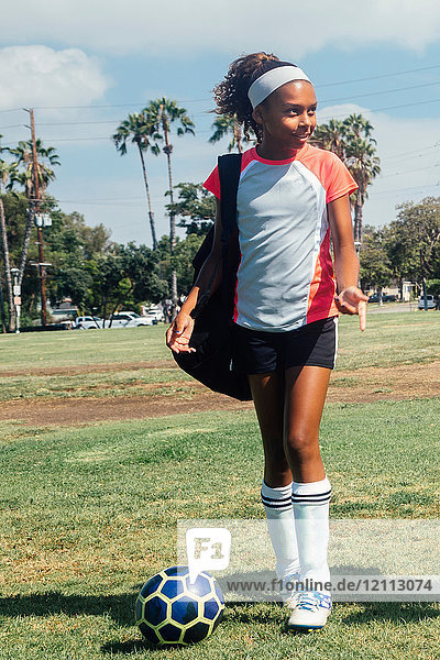 Teenage schoolgirl soccer player on school sports field
