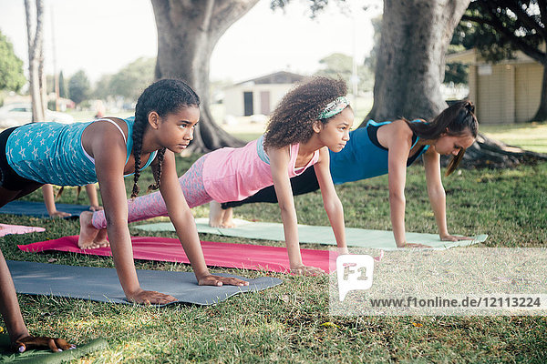 Mädchen und Teenager-Schülerinnen  die Yoga-Brettchen üben  posieren auf dem Schulhof