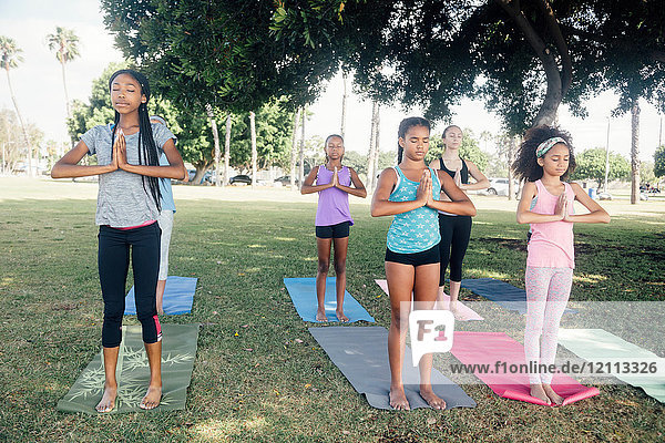 Mädchen und Teenager-Schülerinnen beim Üben von Yoga-Berghaltung auf dem Schulhof