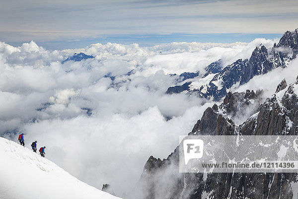 Mountain climbers departing Aiguille du midi  surrounded by French Alps summits; Chamonix-Mont-Blanc  Haute-Savoie  France