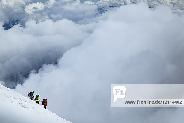Mountain climbers departing Aiguille du midi into the clouds; Chamonix-Mont-Blanc  Haute-Savoie  France