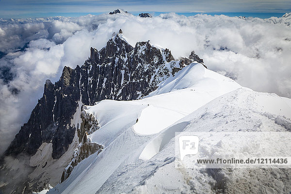 Mountain climbers departing Aiguille du midi  Aiguille du Plan summit in the background; Chamonix-Mont-Blanc  Haute-Savoie  France