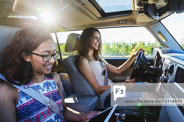 Zwei junge Frauen fahren in einem Auto auf einer Autoreise; Edmonton  Alberta  Kanada