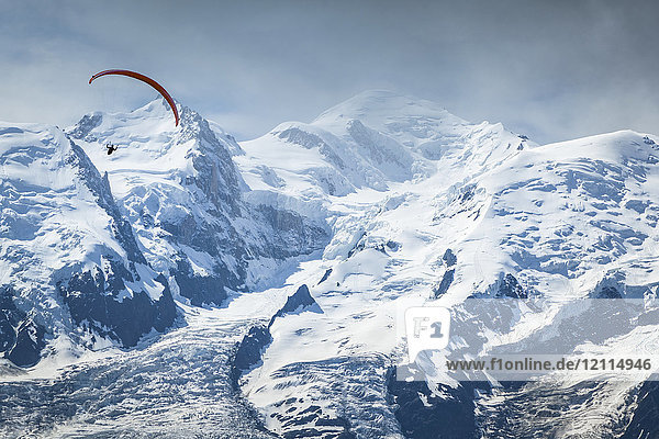 A paraglider flying over Mount Blanc in summer  Alps; Chamonix-Mont-Blanc  Haute-Savoie  France