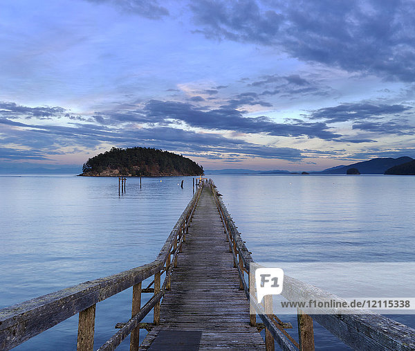 Ein hölzerner Pier  der bei Sonnenuntergang in die Bennet Bay auf den Gulf Islands führt; Mayne Island  British Columbia  Kanada