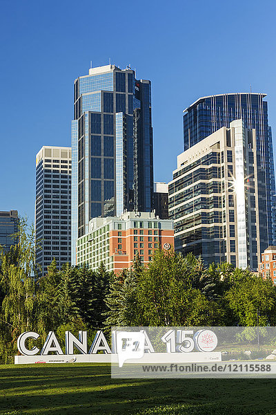 Canada 150-Schild im Stadtpark mit Calgary Gebäude Türme im Hintergrund mit blauem Himmel; Calgary  Alberta  Kanada