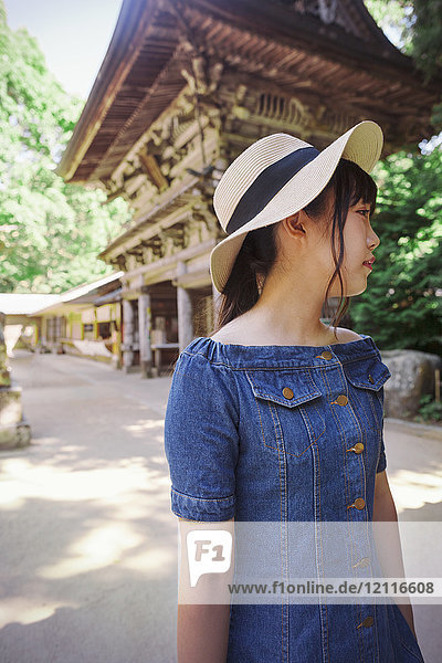 Junge Frau in blauem Kleid und Hut am Shinto Sakurai-Schrein  Fukuoka  Japan.