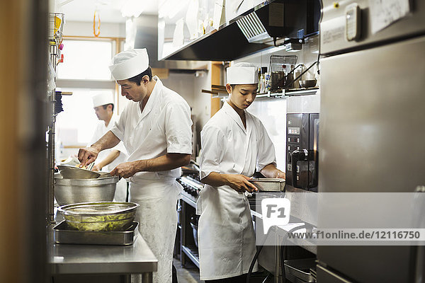 Zwei Köche arbeiten in der Küche eines japanischen Sushi-Restaurants.