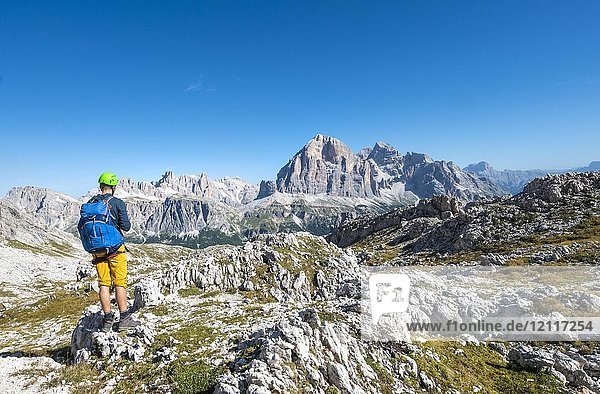 Hiker with climbing helmet on hiking trail to the Nuvolau  view of the mountain range Tofane  Dolomites  South Tyrol  Trentino-Alto Adige  Italy  Europe