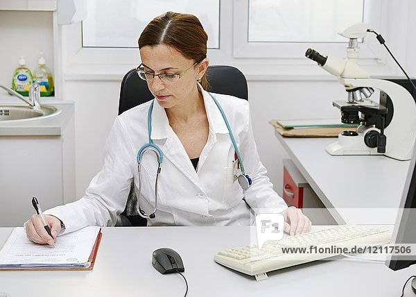 Ärztin bei der Arbeit an ihrem Schreibtisch