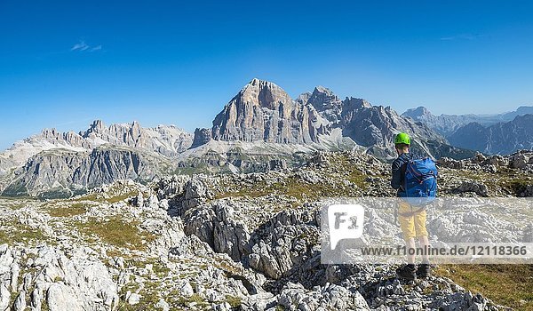 Hiker with climbing helmet on hiking trail to Nuvolau  view of the mountain range Tofane  Dolomites  South Tyrol  Trentino-Alto Adige  Italy  Europe